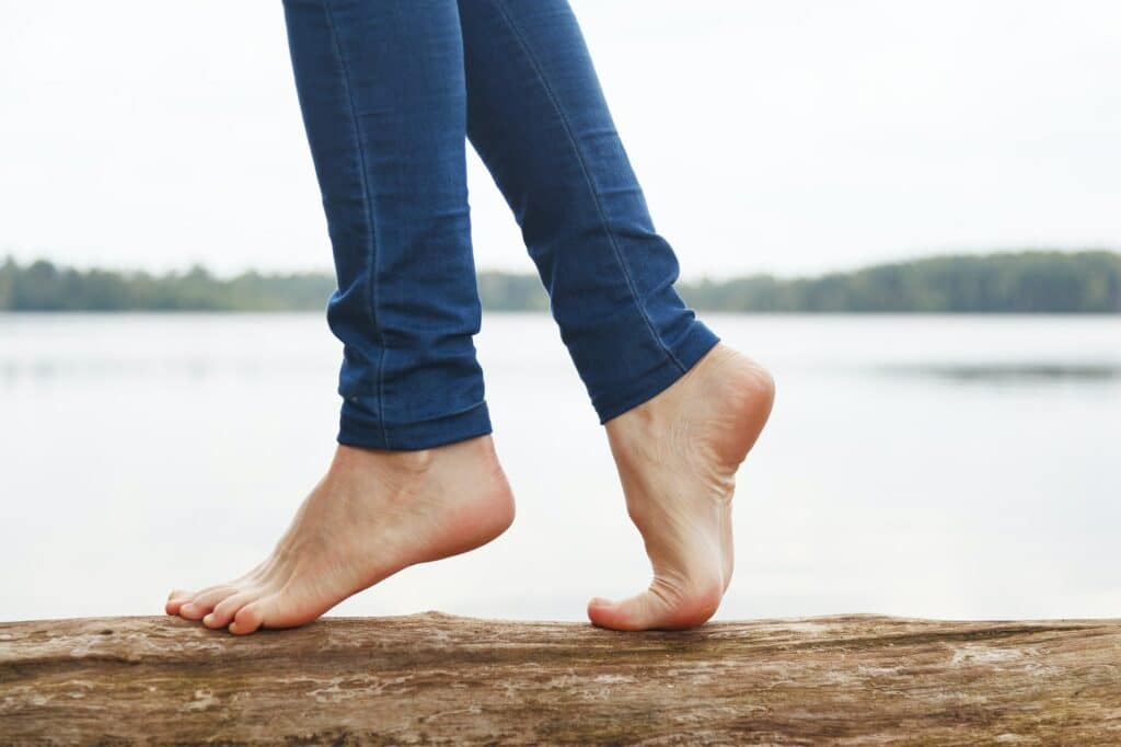 Womans feet walking on a log